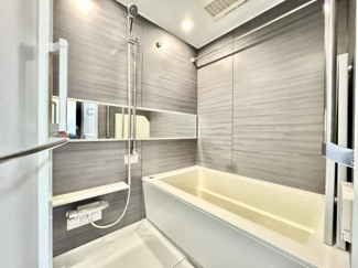 温水洗浄機能付きのトイレです。明るく清潔感があり、白を基調とした内装で空間が広く感じられます。壁面上部には清掃用具を収納できるスペースを設けております。