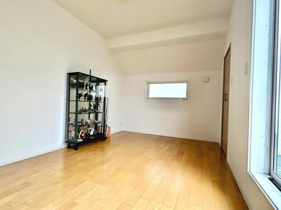 明るいフローリングが印象的な洋室です。壁や天井が白で統一されており室内がすっきりと見えます。窓からの採光があり日中も快適に過ごせます。収納スペースも確保されています。