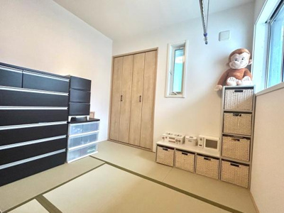 明るい光が差し込む和室です。壁際に収納スペースが豊富に配置されています。畳の落ち着いた色合いが空間に調和しています。シンプルな内装で使い勝手の良い印象です。窓があり換気もしやすいです。
