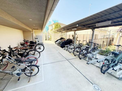 屋根付きの駐輪スペースがあるため自転車やバイクを雨から守りやすいです。ゆとりのある配置で出し入れがしやすそうです。きれいな舗装がされており清潔感があります。複数台の自転車も置ける広さが特徴です。