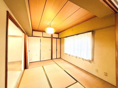 シンプルな畳の和室です。障子やふすまが伝統的な雰囲気を演出しています。やわらかな光が部屋全体を包んでいます。広々とした空間が印象的です。清潔感があり落ち着きのある室内です。
