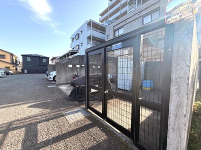 しっかりとしたフェンスで囲まれたゴミ置き場が設置されています。敷地内に駐車スペースも確保されています。建物周辺が開けており車両の出し入れもしやすいです。周囲に高い建物があり隣接環境も落ち着いています。