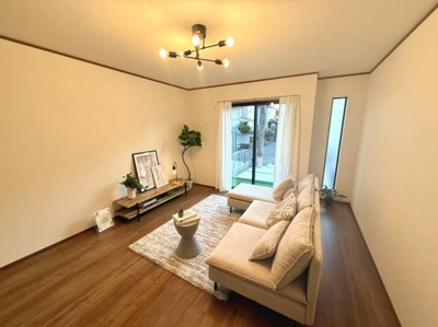 落ち着いた色合いの床材が空間全体に温もりをもたらします。大きな窓からたっぷりと自然光が入るリビングです。シンプルな内装で幅広いインテリアに合わせやすい点が魅力的です。