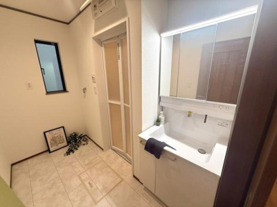 明るい空間に設置された洗面台は収納スペースも確保されており整理しやすいです。広々とした床面で動きやすさが魅力です。窓からの自然光も取り入れやすく換気もスムーズに行えます。