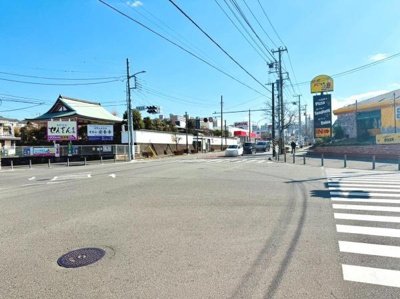 現地からは開放的な眺めが広がっています。周辺には商業施設や飲食店が点在しており利便性が感じられます。歩道も広く見通しの良い道路が特徴です。交差点付近で交通アクセスの確認も容易に行えます。