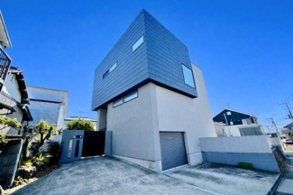 シャープな外観が目を引く建物です。前面道路から敷地内へのアプローチが広く確保されています。駐車スペースもゆとりのある設計で車の出し入れもスムーズです。全体的にシンプルで洗練された印象を与えます。