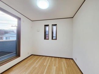 二面採光で明るく室内がすっきりとした洋室です。シンプルな内装で家具の配置がしやすい空間です。床材の風合いが落ち着いた印象を与えます。窓から外の様子もうかがえます。