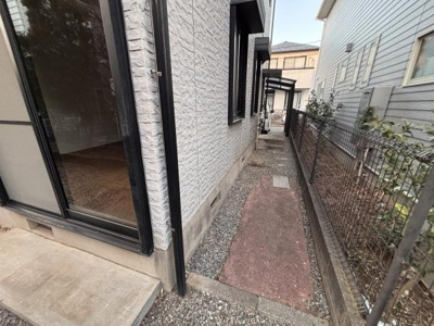 建物の横にしっかりとした通路が確保されています。フェンスが設置されており隣地との境界が明確です。外壁のデザインが落ち着いた印象を与えています。窓からの採光も期待できます。