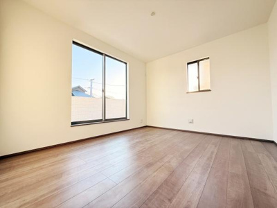 大きな窓からたっぷりと自然光が入る洋室です。シンプルな内装で家具の配置もしやすい設計となっています。落ち着いた色合いのフローリングが空間を広く感じさせます。