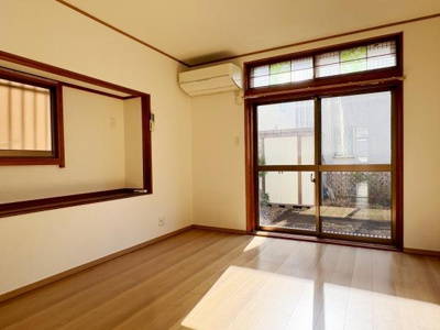 大きな窓からたっぷりと自然光が差し込むリビングです。温かみのあるフローリングが落ち着いた雰囲気を演出します。エアコン付きで一年中快適に過ごせます。室内から見える庭の景色もポイントです。