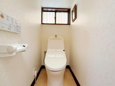 シンプルで清潔感のあるトイレです。窓が設けられており明るさが感じられます。壁面もすっきりとしたデザインとなっています。温水洗浄便座付きの仕様です。ペーパーホルダーも設置されています。