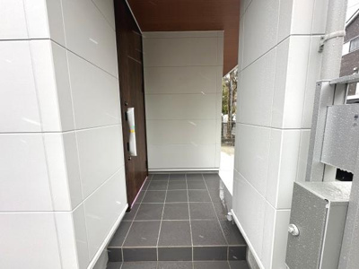 玄関はゆとりのある設計でスムーズな出入りが可能です。タイル仕上げでお手入れもしやすく落ち着いた雰囲気が漂います。建物全体と調和したモダンなデザインが特徴です。