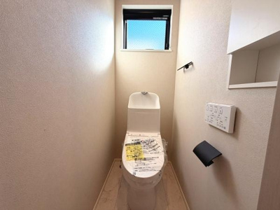 シンプルで使いやすいトイレです。換気用の窓があり空気の入れ替えが可能です。壁に操作パネルが設置されていて手元で操作できます。収納棚が付いているので小物の整理にも便利です。