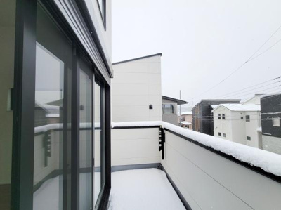 建物と調和したシンプルなバルコニーです。ガラス戸から明るい光が差し込み開放的な設計となっています。周囲は住宅街の落ち着いた雰囲気が広がります。手すり部分はしっかりとした造りです。