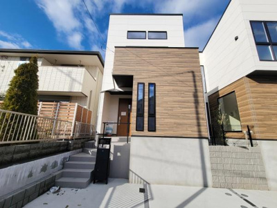 モダンなデザインが特徴的な外観です。シンプルで洗練されたフォルムが印象的です。2階部分の大きな窓が明るさを演出しています。ウッド調の外壁がアクセントとなり全体に統一感があります。