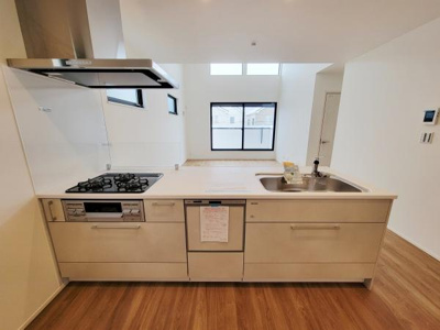 リビングは大きな窓と高い天井が特徴で開放感を感じられます。白を基調とした内装が明るさを引き立てています。フローリングの床も清潔感があります。