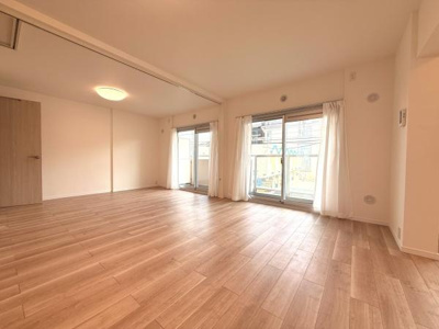 大きな窓から自然光が差し込む明るいリビングです。木目調フローリングが落ち着いた雰囲気を演出しています。開放感があり空間を広々と使えます。シンプルな内装なので家具の配置を自由に楽しめます。