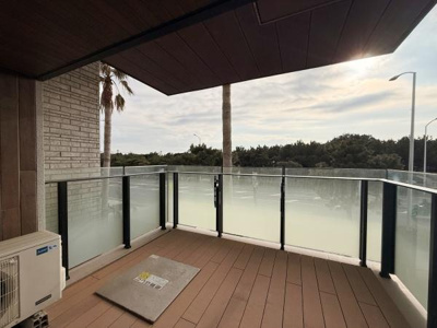 開放感のあるバルコニーはガラスパネルを使用し視界を確保しています。屋根付きで天候の影響も抑えられます。目の前には緑も広がり落ち着いた雰囲気が感じられます。