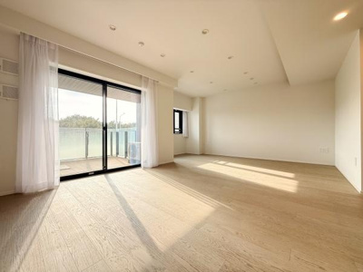 大きな窓からたっぷりと光が入り明るさを感じられるリビングです。フローリングの質感も印象的ですっきりとした空間に仕上がっています。広さを活かしたレイアウトが可能でさまざまな用途に対応できます。