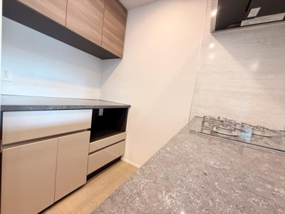 収納が豊富なキッチンで作業スペースもしっかり確保されています。落ち着いたトーンのデザインが魅力的です。コンロ横のカウンターが使い勝手の良いレイアウトになっています。シンプルで使いやすい印象です。