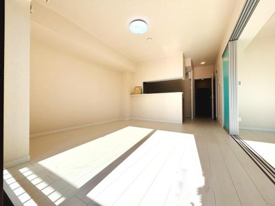 明るい光が差し込むリビングです。隣接するスペースと一体感があり開放的な空間が広がっています。清潔感のある内装でさまざまなインテリアに合わせやすい仕様です。床や壁もシンプルな色合いで統一されています。