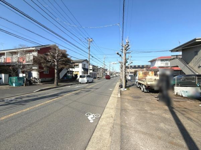 前面道路が広く車の出し入れもしやすい環境です。周囲には住宅が並び落ち着いた雰囲気が感じられます。道路沿いには歩道もしっかりと整備されています。電線や街路樹も整然と配置されています。
