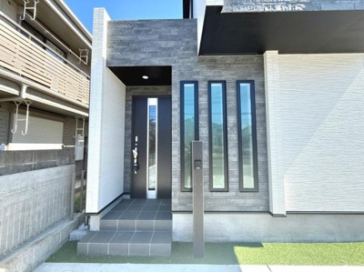 スタイリッシュな外観が印象的な玄関です。横長の窓が採光を意識したデザインとなっています。重厚感のある扉が建物全体の雰囲気を引き締めます。エントランスのステップも広々しています。