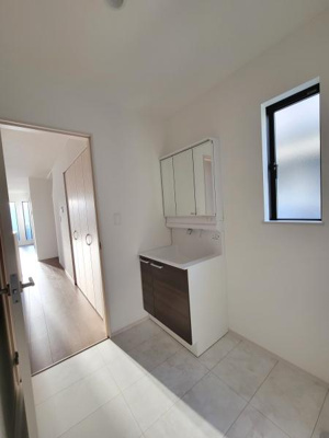 洗面所は明るく清潔感のある空間です。収納力のある洗面台で日常使いに便利です。窓付きで自然換気ができます。鏡が大きく使い勝手にも配慮されています。すっきりとしたデザインが特徴的です。