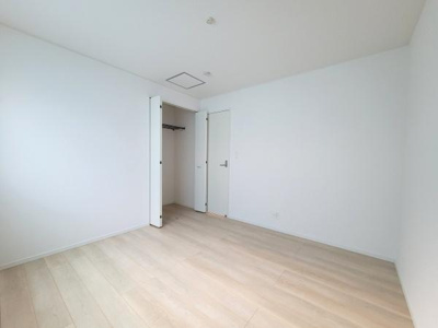 明るい色合いのフローリングが特徴の洋室です。シンプルな内装で家具のレイアウトもしやすい空間になっています。奥には収納スペースがあり便利です。清潔感のある印象の洋室です。