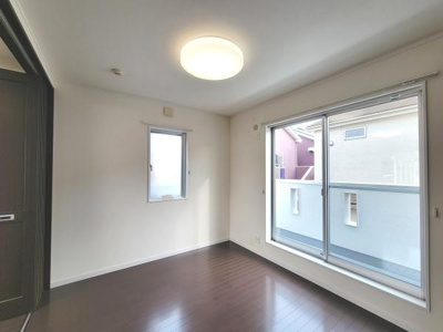 大きな掃き出し窓から自然光が差し込む洋室です。フローリングが上品な印象を与えます。収納スペースも備わっており使い勝手が良い空間となっています。