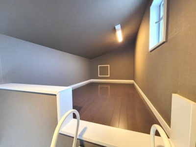 落ち着いた色合いの内装が印象的なロフトスペースです。窓から自然光が差し込み通気性にも配慮された設計です。照明も設置され利便性の高い空間となっています。収納や趣味のスペースとしても使いやすい形状です。