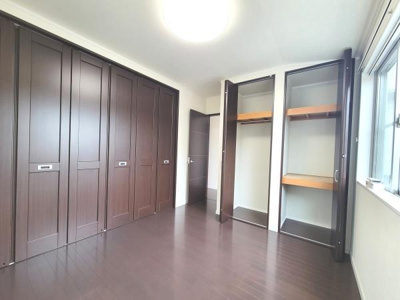 落ち着いた色合いのフローリングと建具が印象的な洋室です。大きなクローゼットが設けられているため収納スペースが充実しています。窓からの自然光も入りやすい明るい室内になっています。