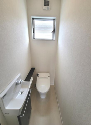 窓付きで換気しやすい2階のトイレです。シンプルな内装でお手入れも簡単です。手洗い器が一体となっていてコンパクトにまとまっています。スペースが有効活用された設計です。清潔感のある空間となっています。