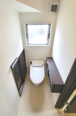 窓付きで明るさを感じられるトイレです。収納が設置されており整理整頓も可能です。換気扇も設置されているため快適な空間が保たれます。シンプルで落ち着いた内装です。