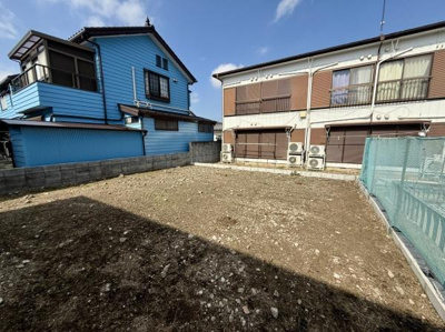 現地土地写真です。陽当たりを感じられる空間となっています。周囲には住宅が並び落ち着いた環境が広がっています。敷地は整形されており建築の際にも利用しやすい形状です。周囲に囲いが設置されています。