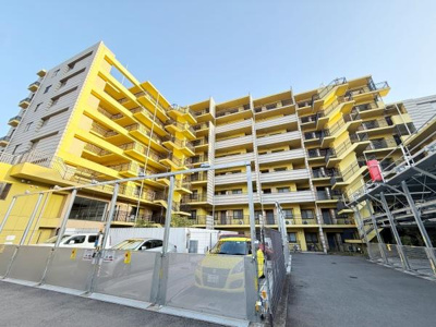 明るい外観が特徴的なマンションです。階段やバルコニー部分も設計が工夫されています。複数台の駐車スペースを備えています。全体が開放的な雰囲気となっています。エントランス周辺も整備されています。