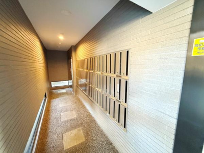 落ち着いた雰囲気のエントランスが魅力です。ゆとりある通路に郵便受けが整然と並んでいます。清潔感あるタイル張りの床が印象的です。奥行きのある空間設計がポイントです。照明の明るさも程よく快適です。