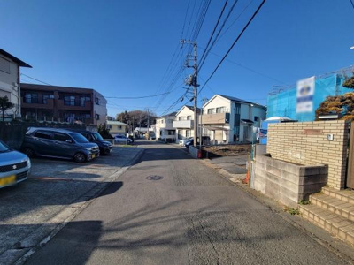 幅のある前面道路が広がり駐車や車の出し入れがしやすい環境です。周囲には閑静な住宅が立ち並び落ち着いた雰囲気が感じられます。電柱や街灯も整っており夜間も安心です。道路の舗装状態も良好で清潔感があります。