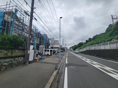 現地前面道路は広々としており車の通行もスムーズです。歩道も確保されていて日常の移動がしやすい環境となっています。周囲には緑も見られ落ち着いた雰囲気が感じられます。