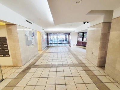 広々としたロビー空間はゆとりを感じられます。明るい光が差し込み落ち着いた雰囲気が広がっています。タイル貼りの床が清潔感を高めます。エントランスからのアクセスもスムーズです。