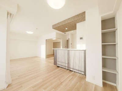 開放感のあるリビングが広がっており明るい雰囲気が特徴です。ナチュラルなフローリングが空間に調和しています。カウンターキッチンがアクセントとなり収納棚も備わっています。