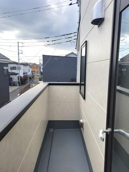 シンプルなデザインのバルコニーは無駄のないレイアウトが特徴です。外壁と床のコントラストが空間を引き締めます。換気しやすい窓と照明も備わっています。扉からのアクセスも便利です。