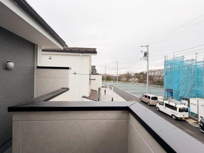 バルコニーからの眺望が広がっています。近隣の建物や道路の様子も見渡せます。