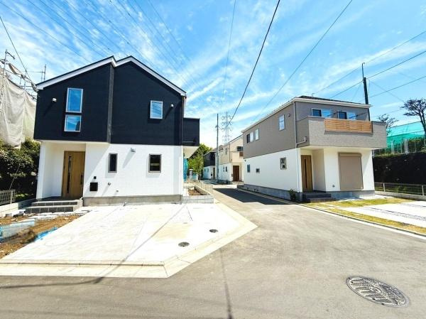 前面道路を含む現地写真です。周囲にゆとりがあり開放感を感じられる配置となっております。日当たりも良好な環境です。建物の外観がシンプルで洗練された印象を与えます。敷地内の駐車スペースも確保されています。