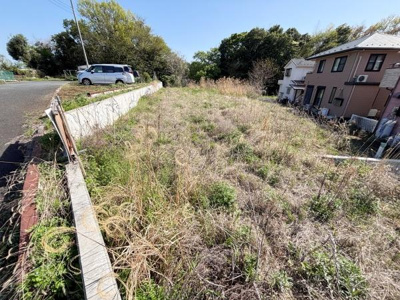 陽当たりの良い現地土地写真です。周囲には緑が広がり落ち着いた環境が感じられます。道路に面しているため出入りもスムーズです。開放感のある土地となっています。