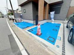 玄関前には広々としたスペースが確保されており車の出し入れがしやすい配置となっています。敷地全体が整った形状で日々の使い勝手にも配慮されています。建物の外壁デザインもモダンな印象を与えてくれます。