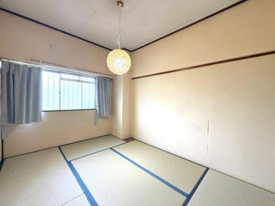 窓からやわらかな光が差し込む落ち着いた和室です。シンプルな内装で自分好みにアレンジしやすい空間となっています。畳の質感も感じられるお部屋です。天井照明がインテリアのアクセントになっています。