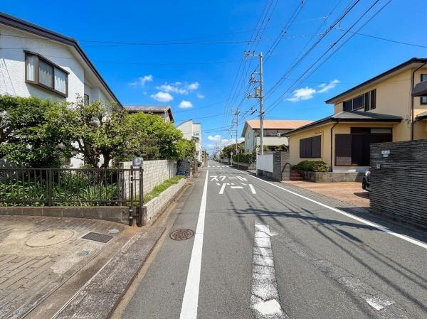 前面道路は幅員がしっかり確保されており交通量も落ち着いたイメージです。両サイドに整った住宅が並び周囲は住宅街の印象です。