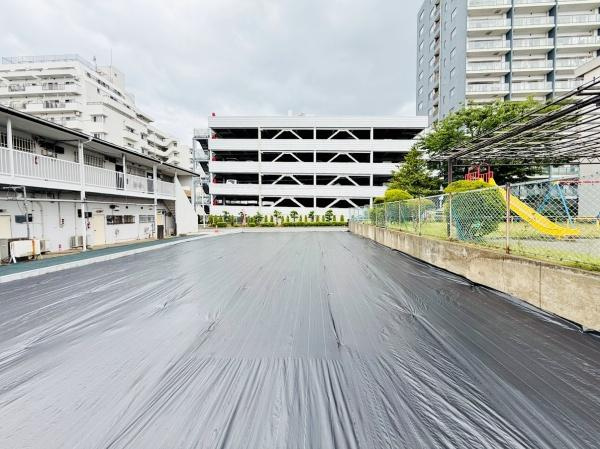 平坦な地形が特徴の土地写真です。周囲には住宅やマンションが立ち並び利便性が感じられます。敷地が広く日当たりも期待できる現地土地写真です。