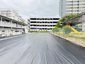 平坦な地形が特徴の土地写真です。周囲には住宅やマンションが立ち並び利便性が感じられます。敷地が広く日当たりも期待できる現地土地写真です。